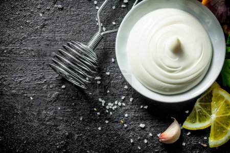 Mayonnaise with lemon and garlic. On black rustic background