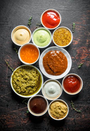 Photo for Barbecue sauce, pesto, mayonnaise, mustard with thyme sprigs. On dark rustic background - Royalty Free Image