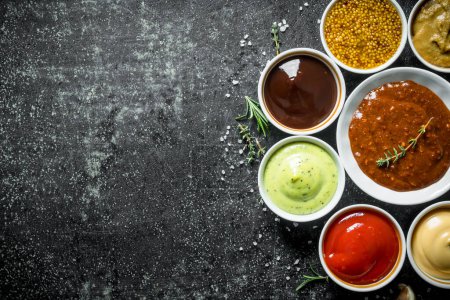 Bowls with sauces. On dark rustic background