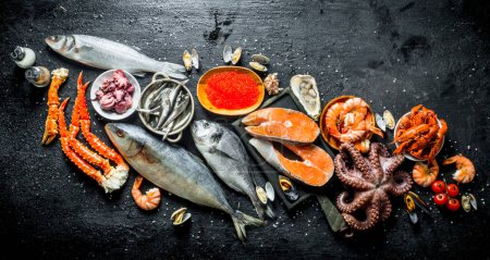 Frisches Lachssteak mit Tintenfisch, Kaviar, Garnelen und Krebsen. auf schwarzem rustikalem Hintergrund