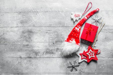 Composición navideña de caja de regalo roja y decoraciones navideñas. Sobre fondo blanco rústico
