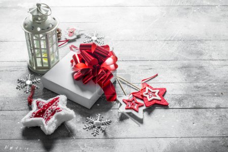 Téléchargez les photos : Bougeoir rétro avec décorations de Noël et coffret cadeau blanc. Sur fond rustique blanc - en image libre de droit