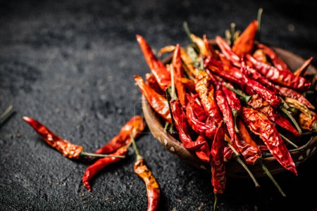 A full plate of dried chili peppers. On a black background. High quality photo