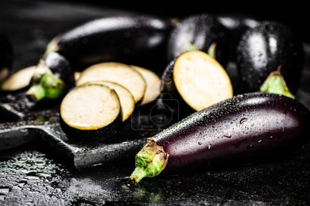 Photo for Cut into pieces on a cutting board of eggplant. On a black background. High quality photo - Royalty Free Image