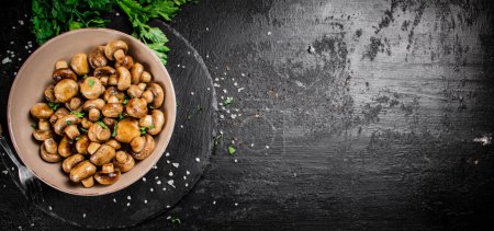 Téléchargez les photos : Delicious fried mushrooms in a bowl. On a black background. High quality photo - en image libre de droit