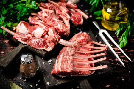 Photo for Raw rack of lamb with parsley on a cutting board. On a dark rustic background. High quality photo - Royalty Free Image