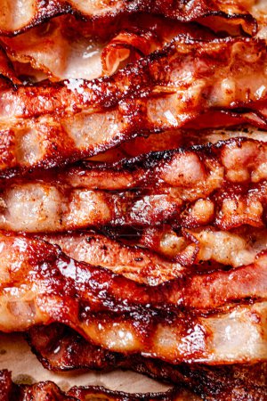 Téléchargez les photos : Des lanières de bacon frit parfumé. Arrière-plan macro. Texture de bacon. Photo de haute qualité - en image libre de droit