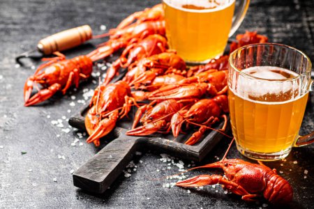 Photo for Boiled crayfish with beer on a cutting board. On a black background. High quality photo - Royalty Free Image