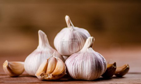 Foto de Cloves of fresh garlic on the table. On a wooden background. High quality photo - Imagen libre de derechos