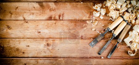 Photo for Chisel with a bunch of wood sawdust. On a wooden background. High quality photo - Royalty Free Image