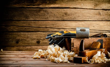 Photo for Hand planer with wooden sawdust. On a wooden background. High quality photo - Royalty Free Image