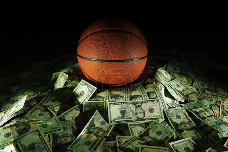 Baloncesto en una pila de dinero en efectivo y apuestas en concepto deportivo 
