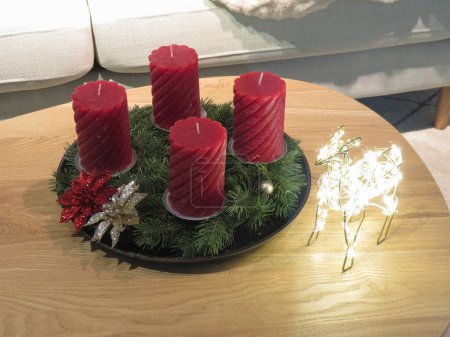 four red candes on a table as Christmas decoration