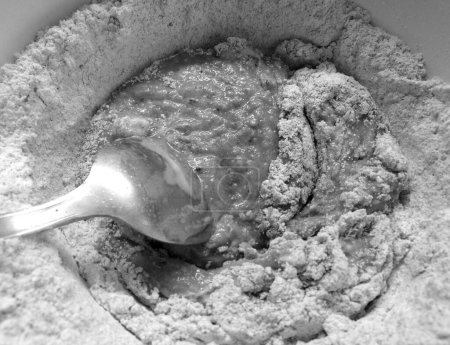 Téléchargez les photos : Adding ingredients for making cocoa flavoured dough, in black and white - en image libre de droit