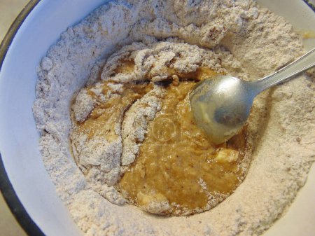 Téléchargez les photos : Adding ingredients for making cocoa flavoured dough - en image libre de droit