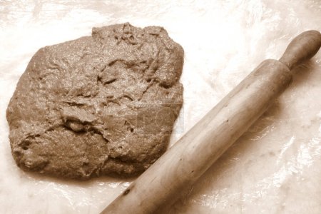 Téléchargez les photos : Cocoa flavoured dough ready to bre streched with a rollin pin, in sepia tones - en image libre de droit
