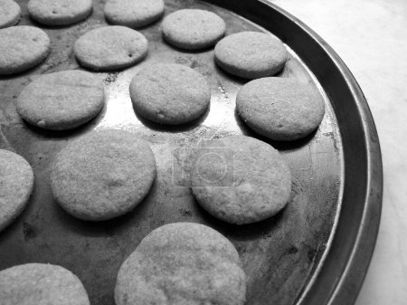 Téléchargez les photos : Recently  baked cocoa flavoured cookies in metalic tray, in black asnd white - en image libre de droit