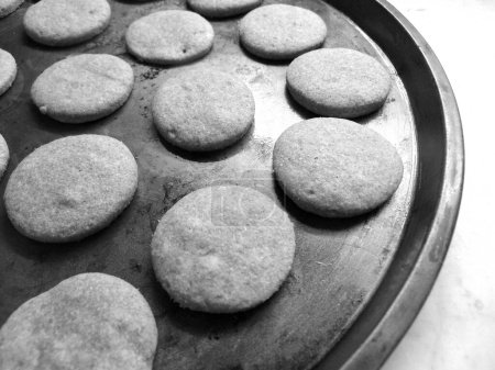 Téléchargez les photos : Recently  baked cocoa flavoured cookies in metalic tray, in black asnd white - en image libre de droit