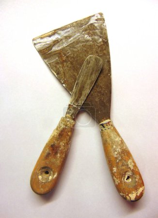 pair of old spatulas stained with plastic plaster