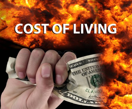 Téléchargez les photos : Une main tenant de l'argent avec le feu en arrière-plan et les mots "coût de la vie". - en image libre de droit
