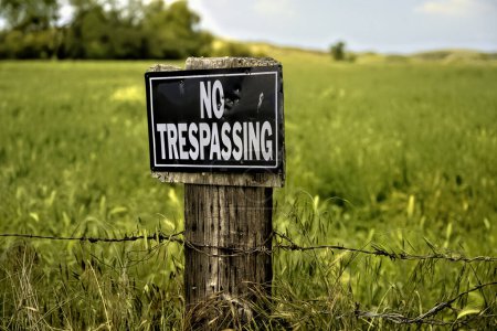 Téléchargez les photos : Aucun signe d'intrusion dans un champ avec du fil barbelé sur le poteau en bois. - en image libre de droit