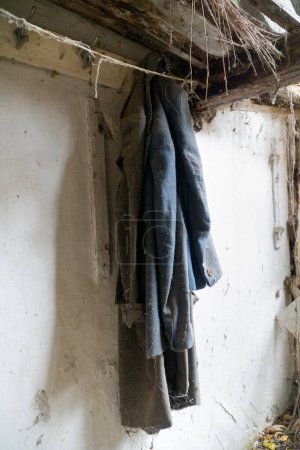 Téléchargez les photos : Ancienne veste hanguin d'un mur à l'intérieur d'une maison détruite à pripyat zone d'exclusion - en image libre de droit