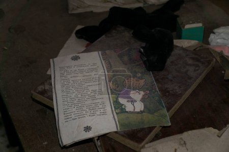 Foto de Niños mayores dibujando un libro de cuentos sobre una mesa de madera dentro de un jardín infantil en la zona de exclusión radiactiva de Chernobyl - Imagen libre de derechos