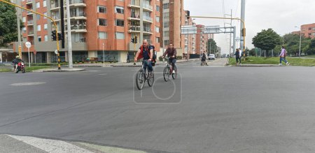 Téléchargez les photos : Deux hommes à vélo sur la piste cyclable à la 147e rue avec le coin de la 9e avenue sur bogota Pas d'événement de jour de voiture - en image libre de droit