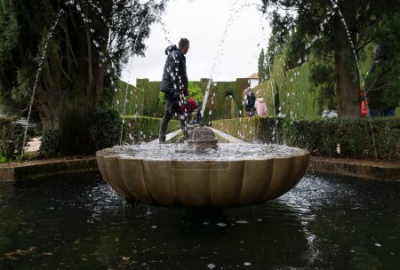 Téléchargez les photos : Generalife gardens polices touriste et arbres - en image libre de droit