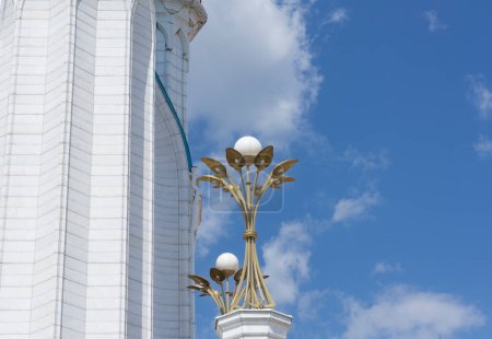 Téléchargez les photos : Belle forme de fleur dorée lampes ezpterior de qol mosquée sarif avec ciel bleu à l'arrière-plan - en image libre de droit