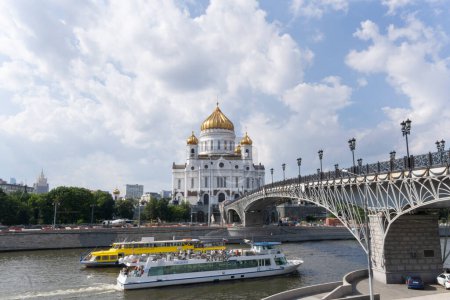 Foto de Catedral de Cristo salvador y puente Patriarshy con barcos touiristic navegando bajo el puente a través del río moskva - Imagen libre de derechos