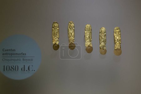 Foto de Primer plano de cinco pequeñas figuras antropomórficas de música dorada en el museo de oro - Imagen libre de derechos
