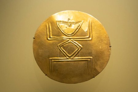 Foto de Antiguo pectoral dorado redondeado de un chamán transformándose en una rana en el museo de oro - Imagen libre de derechos