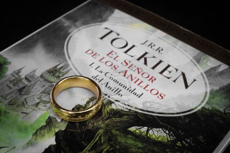 Photo for Closeup to a Ring of power of lord of the rings history over the lord of the rings the fellowship of the ring text book front page in spanish - Royalty Free Image