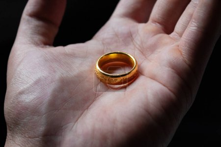 Photo for The one ring of the lord of the rings movie over a male hand and dark background - Royalty Free Image