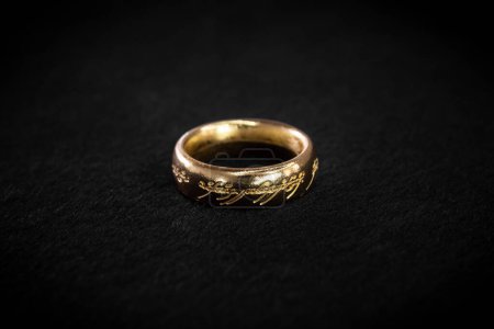 Téléchargez les photos : Gros plan sur un seigneur des anneaux anneau de puissance ou un anneau de sauron sur un fond noir - en image libre de droit
