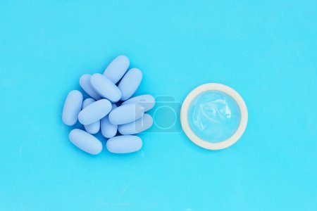 Photo for Condom with PrEP ( Pre-Exposure Prophylaxis) blue pills used to prevent HIV - Royalty Free Image