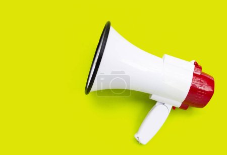Red and white megaphone on green background.