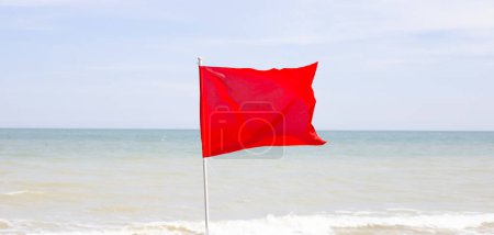 Téléchargez les photos : Un drapeau rouge. Panneau d'avertissement sur la plage - en image libre de droit