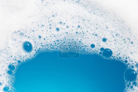 Waschmittel Schaumstoffblase auf dem Wasser. Blauer Hintergrund, Seifenlauge