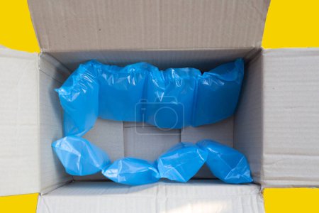 Foto de Cojín de aire azul bolsas de plástico de embalaje en caja de cartón - Imagen libre de derechos