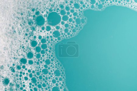 Foto de Burbuja de espuma detergente en Wate. Fondo azul, jabón sud - Imagen libre de derechos