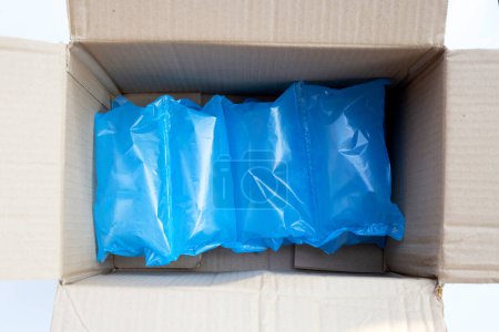 Foto de Cojín de aire azul bolsas de plástico de embalaje en caja de cartón - Imagen libre de derechos