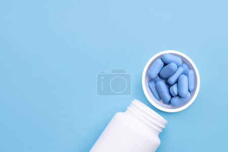 Photo for PrEP ( Pre-Exposure Prophylaxis) used to prevent HIV, in plastic pill bottle cap on blue background, Copy space - Royalty Free Image