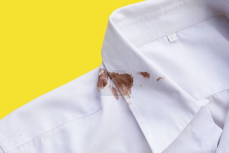 Téléchargez les photos : Sale tache de choclate sur chemise blanche - en image libre de droit