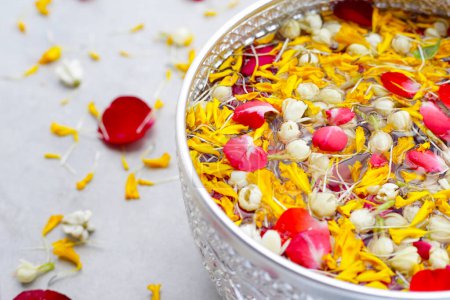 Téléchargez les photos : Eau avec fleur de jasmin, pétale de souci et pétale de rose dans un bol en argent. Tradition thaïlandaise, Festival de Songkran - en image libre de droit
