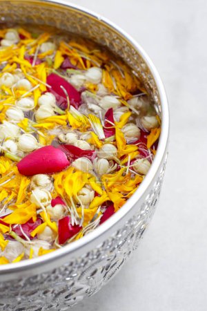 Téléchargez les photos : Eau avec fleur de jasmin, pétale de souci et pétale de rose dans un bol en argent. Tradition thaïlandaise, Festival de Songkran - en image libre de droit