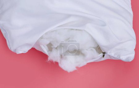 Oreiller blanc avec fibre polyester stable sur fond rose.