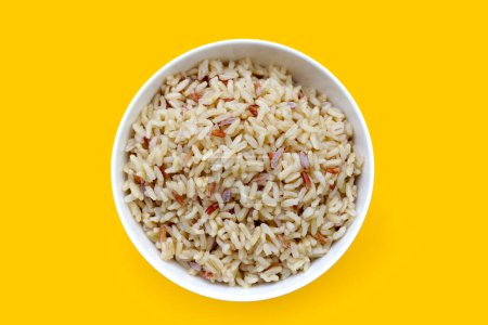 Cooked brown rice on yellow background.