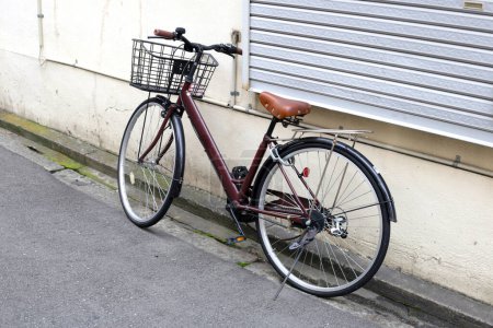 Brown bicycle on the sidewalk.